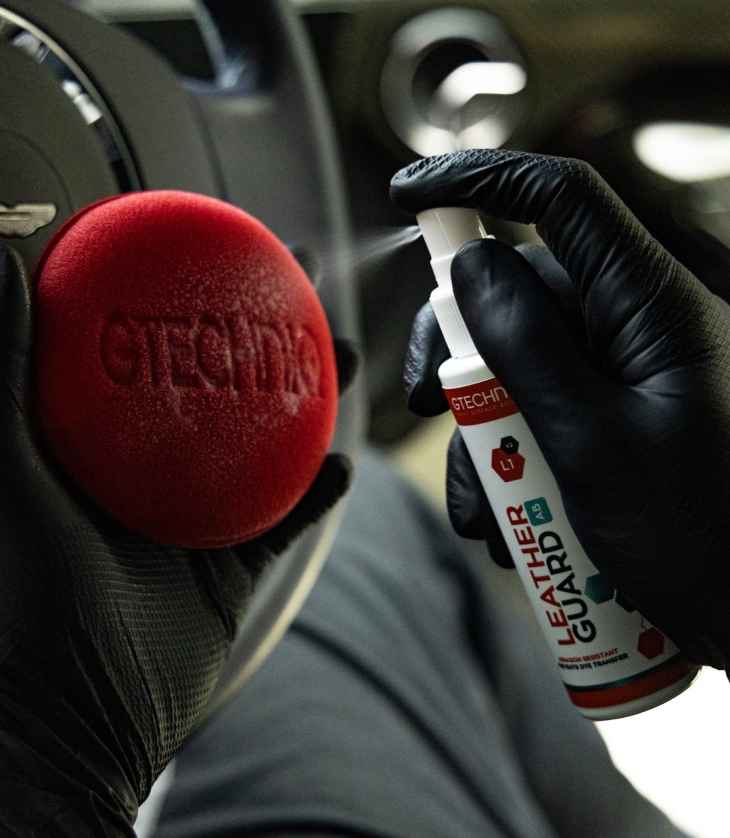 Gtechniq L1 Leather Guard being sprayed onto an applicator pad for protecting leather